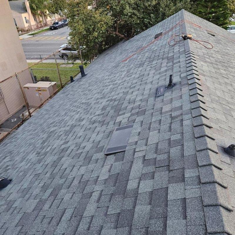 Shingle roof with vents and ridge cap in urban area Shingle roof with vents and ridge cap in urban area