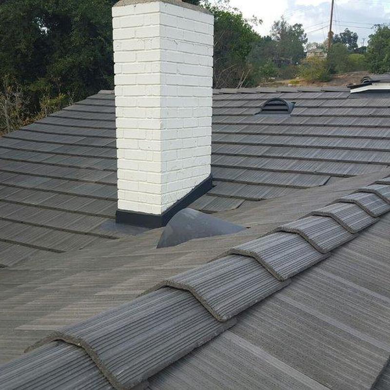 Tile roof with white brick chimney and vent boots Tile roof with white brick chimney and vent boots