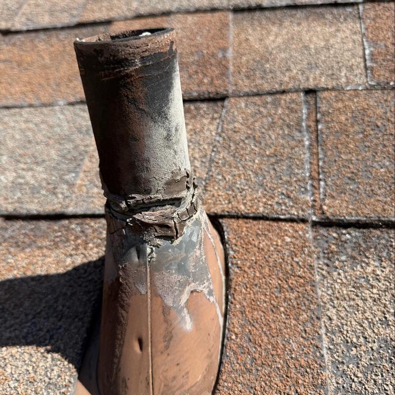 Plumbing vent pipe with cracked flashing on shingle roof Plumbing vent pipe with cracked flashing on shingle roof