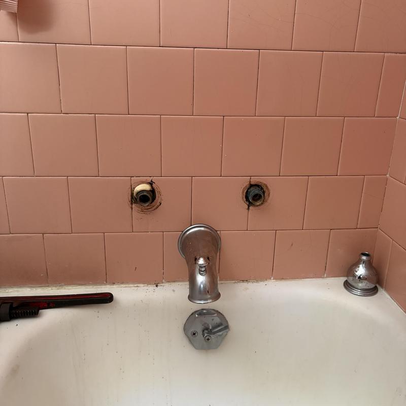 Two-handle shower valve removed from old tile wall