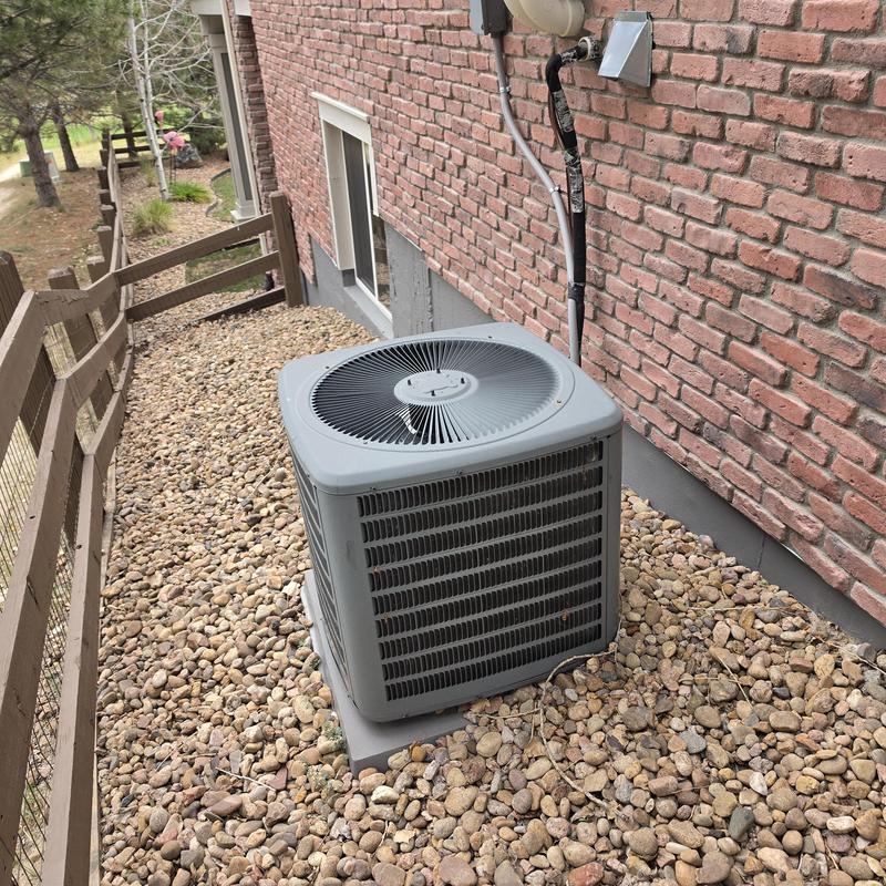 Goodman air conditioner unit next to brick wall Goodman air conditioner unit next to brick wall