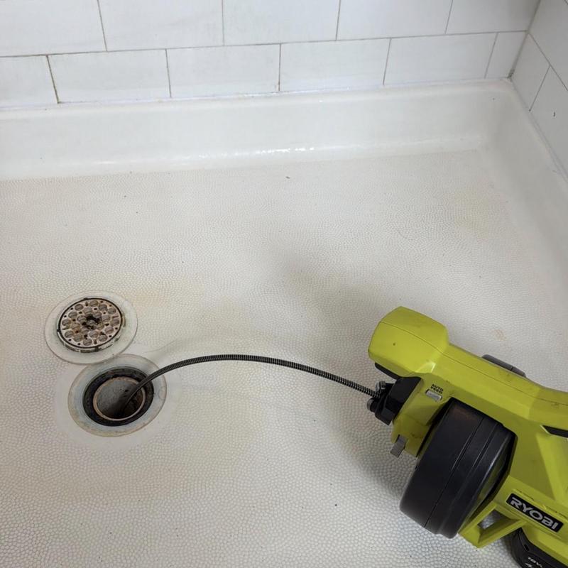 Shower drain with plumbing auger clearing clog Shower drain with plumbing auger clearing clog