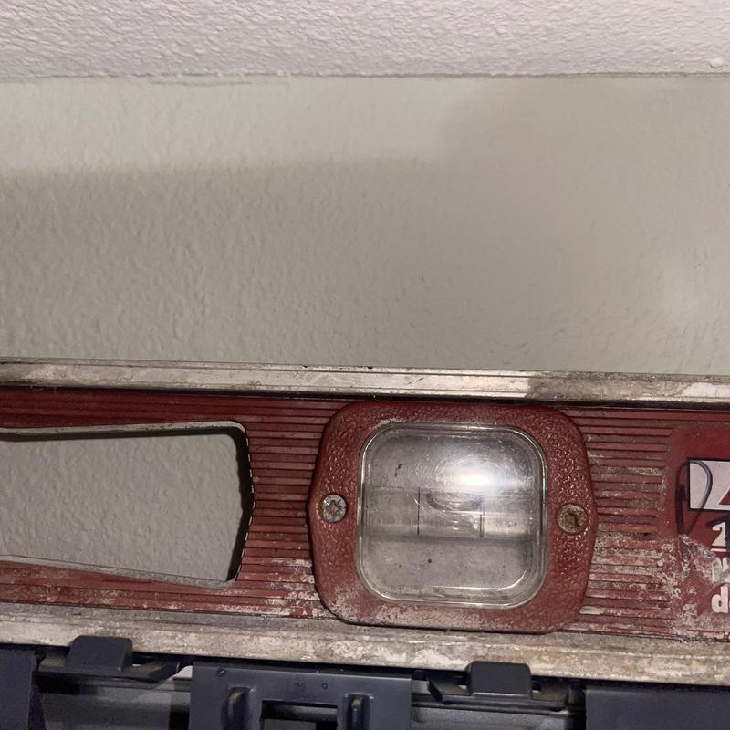 Mini split drain pan level checked with spirit level