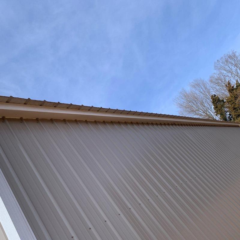 Metal roof panels with ridge cap and gutters