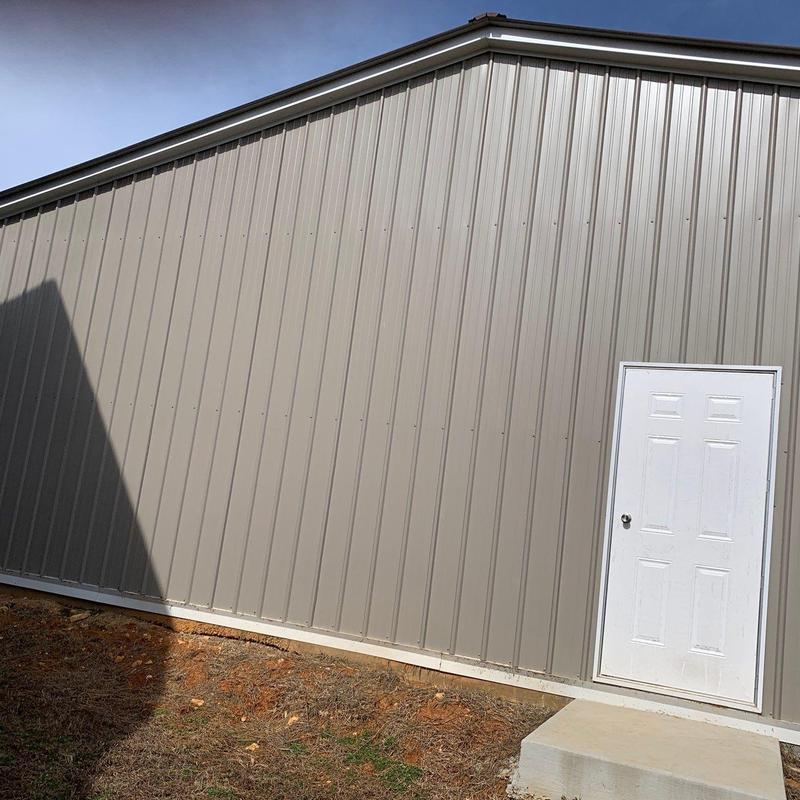 Metal building exterior wall with white door and shadow