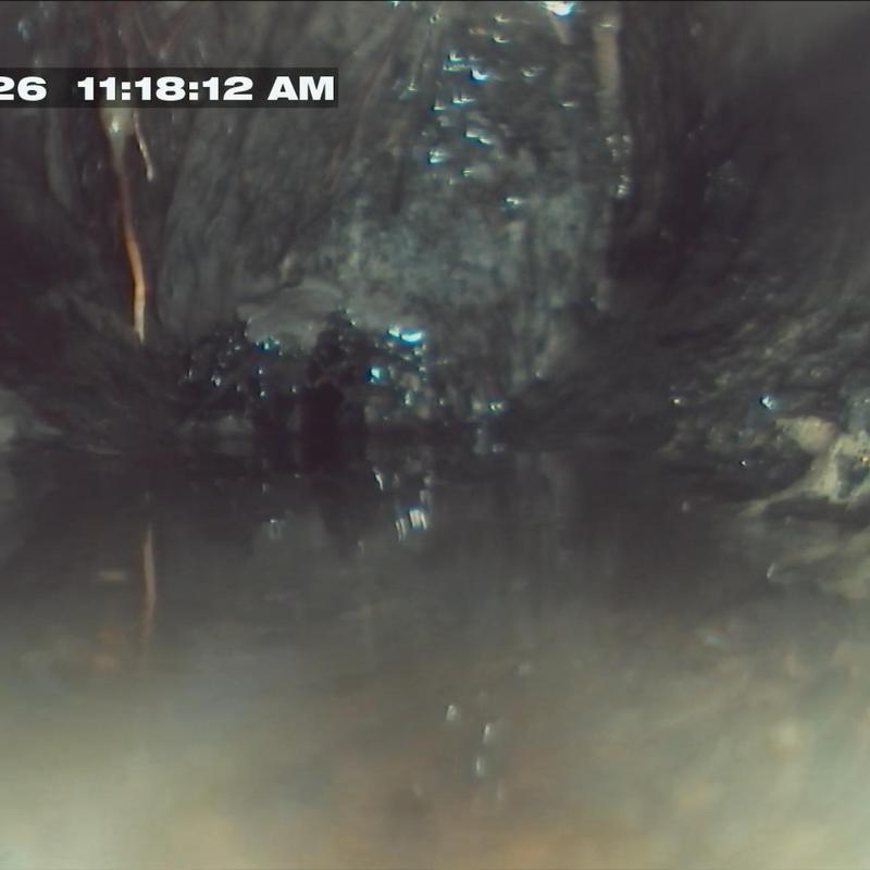 Sewer line interior with water and debris buildup