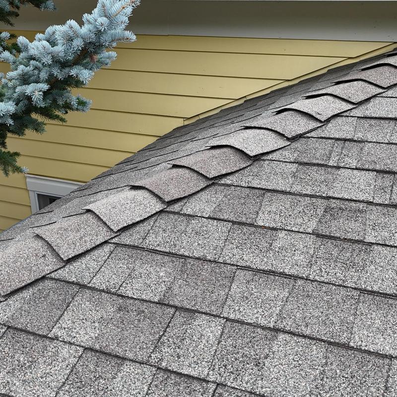 Asphalt shingle roof ridge and shingles on house