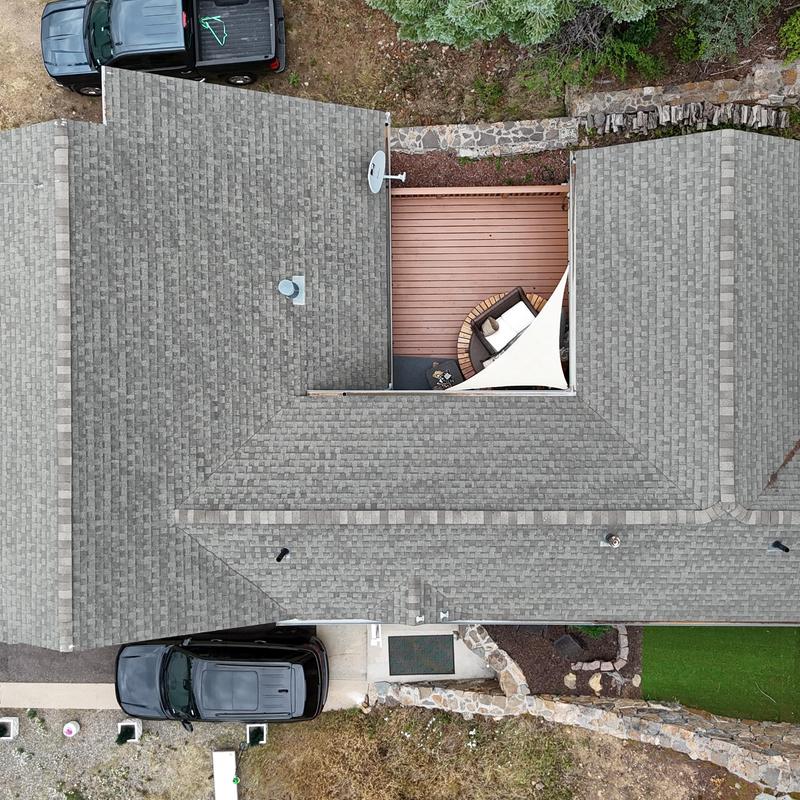 Asphalt shingle roof aerial view with vehicles parked