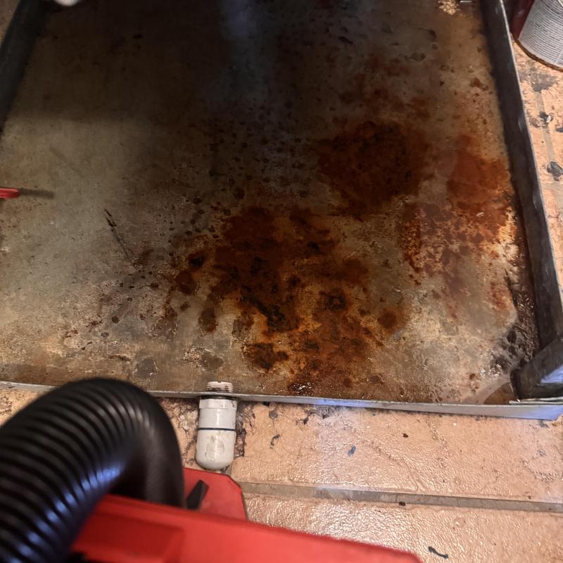 Heat pump drip pan with rust and debris cleaning