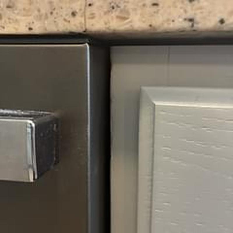 Dishwasher edge and dishwasher door handle close-up