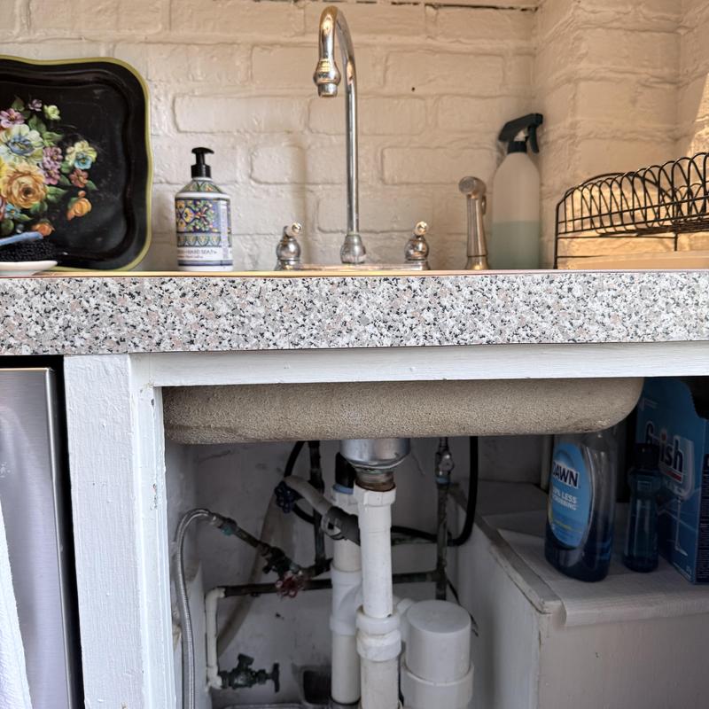 Kitchen sink faucet and drain plumbing under counter