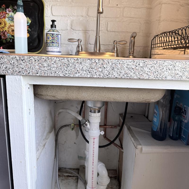 Kitchen sink drain and faucet installation under counter