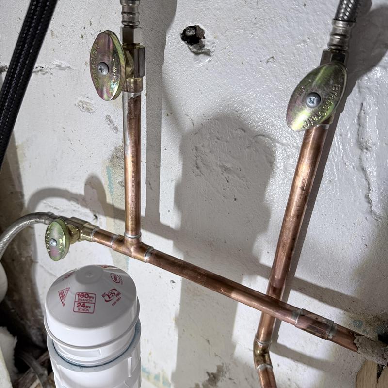 Copper stop valves and piping installations under sink
