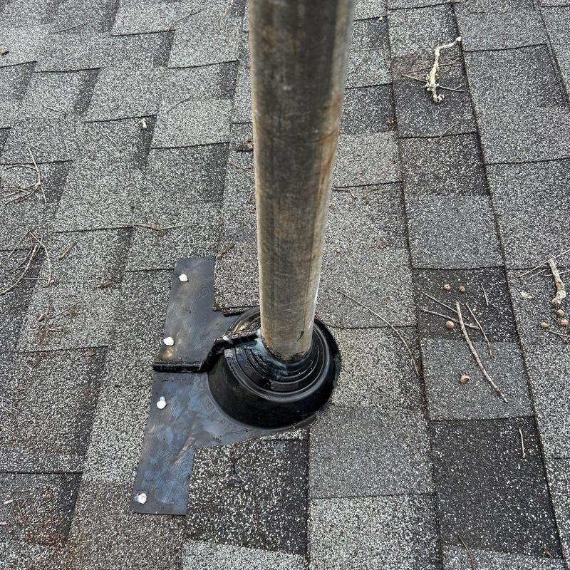 Roof flashing around metal pipe on shingled roof