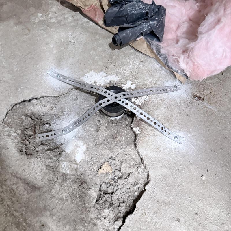 Backwater valve capped with metal straps in basement floor Backwater valve capped with metal straps in basement floor