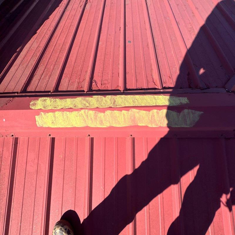 Metal roof panel with hail damage marked for repair