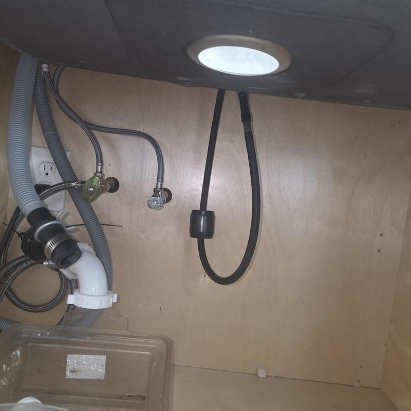 Garbage disposal plumbing and dishwasher drain hoses under sink Garbage disposal plumbing and dishwasher drain hoses under sink