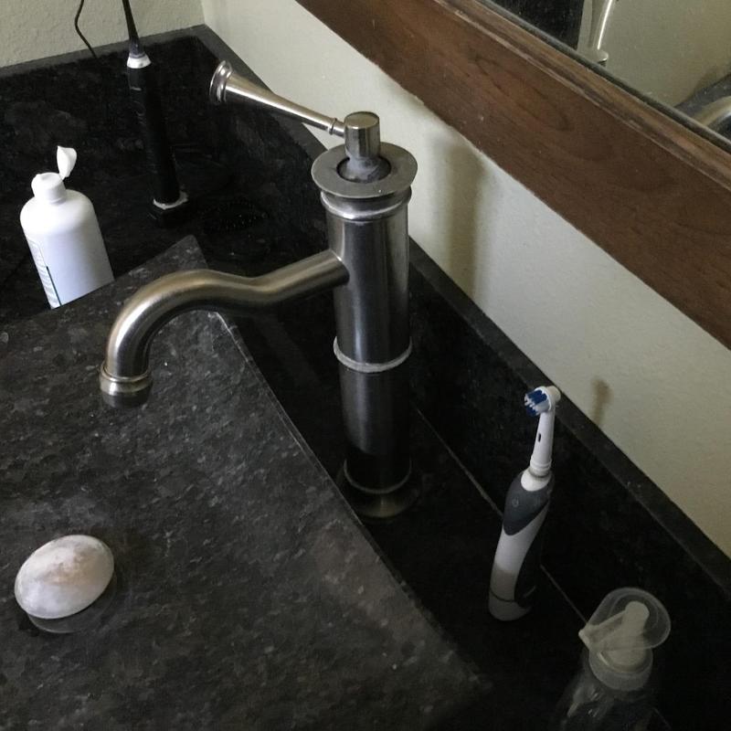 Bathroom sink faucet with soap and toothbrush nearby