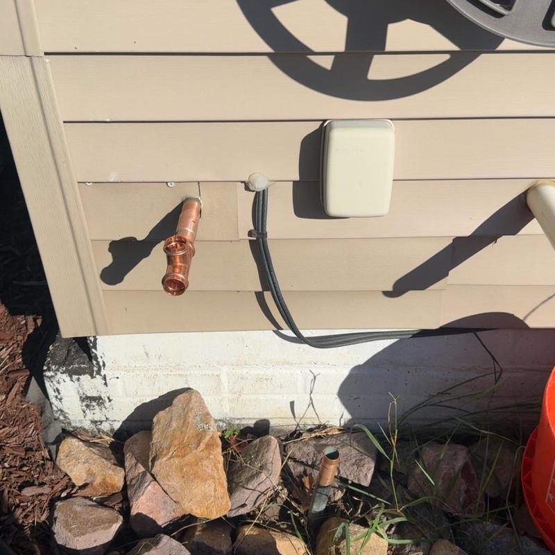 Copper vacuum breaker pipe on house exterior wall Copper vacuum breaker pipe on house exterior wall