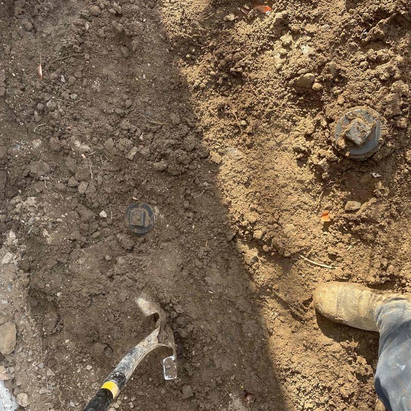 Cast iron pipe excavation with plumbing tools in soil