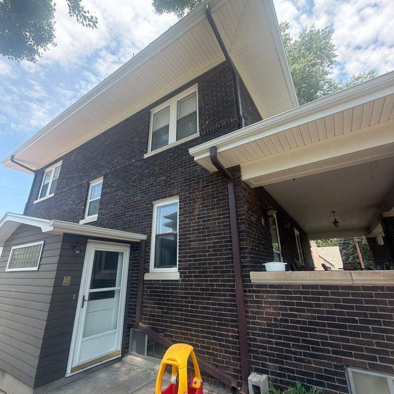Roof edging and gutters on dark brick house exterior Roof edging and gutters on dark brick house exterior
