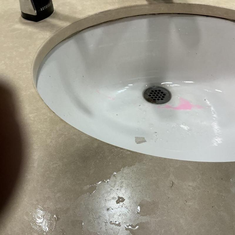 Soap dispenser installed next to bathroom sink drain Soap dispenser installed next to bathroom sink drain