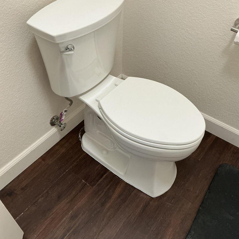 Toilet installation on dark wood floor in bathroom Toilet installation on dark wood floor in bathroom