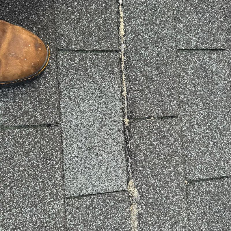 Three tab asphalt shingles with edge tab loss and boot