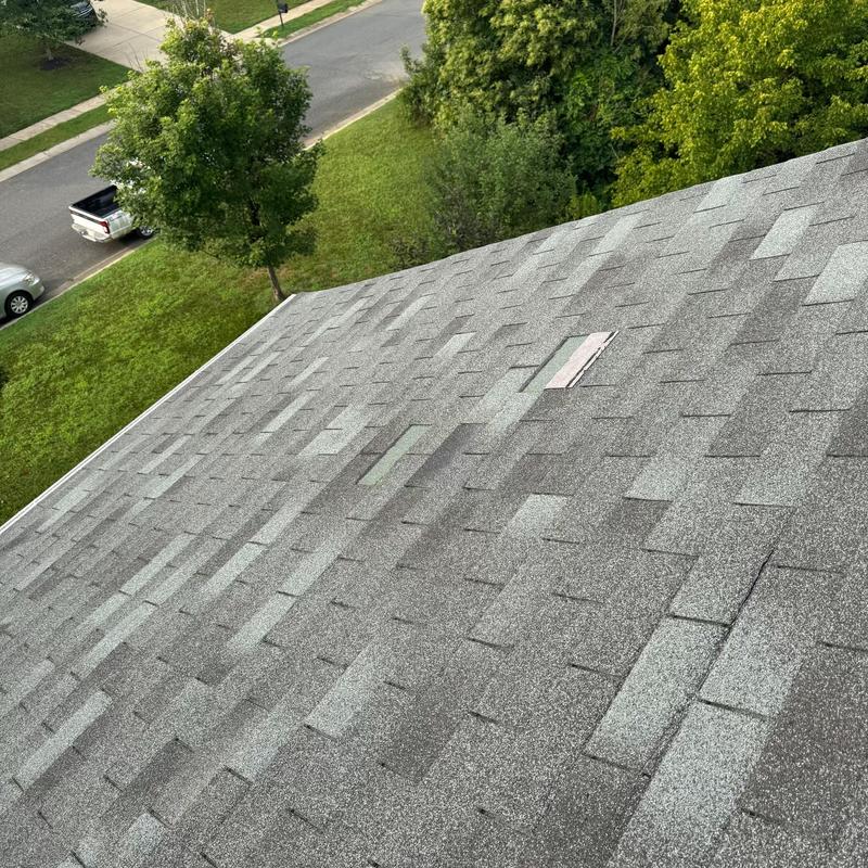 Three tab roof shingles with missing tabs and damage