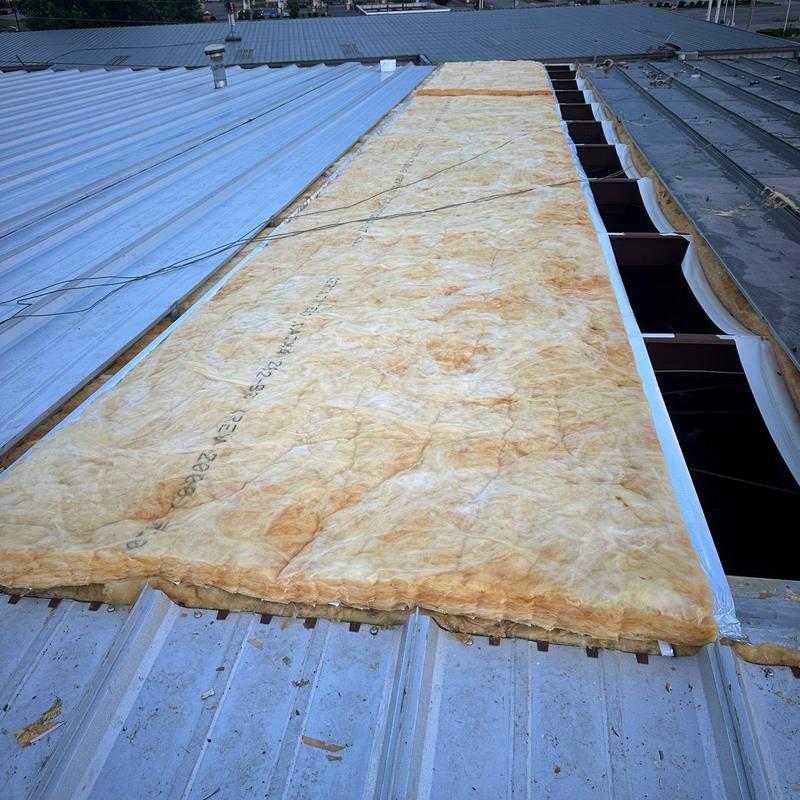Metal roof insulation installation over steel panels