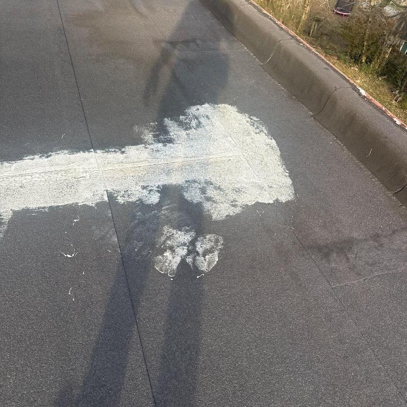 Flat roofing with patch repair and hail damage signs