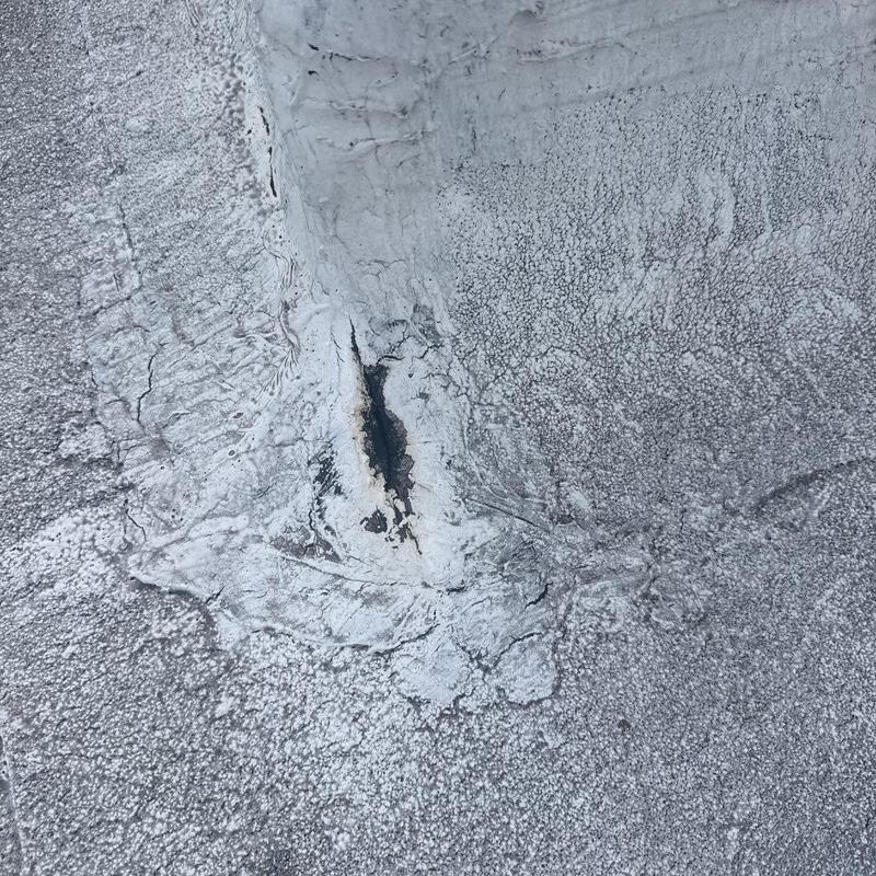Commercial roof flashing with hail damage and cracks
