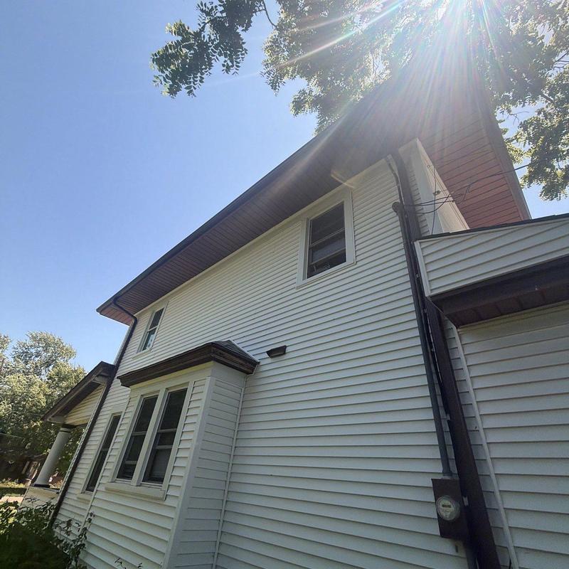 Roof shingles and gutters on white house exterior Roof shingles and gutters on white house exterior
