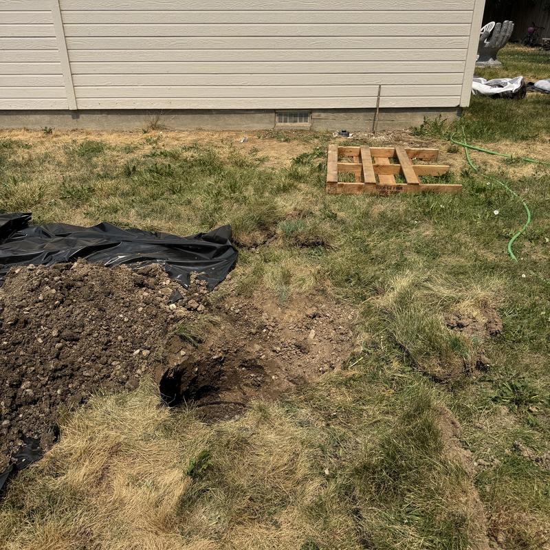 Septic tank drain field excavation near house exterior