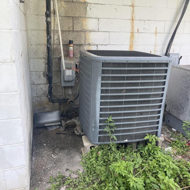 Outdoor air conditioning condenser unit with wiring and pipes