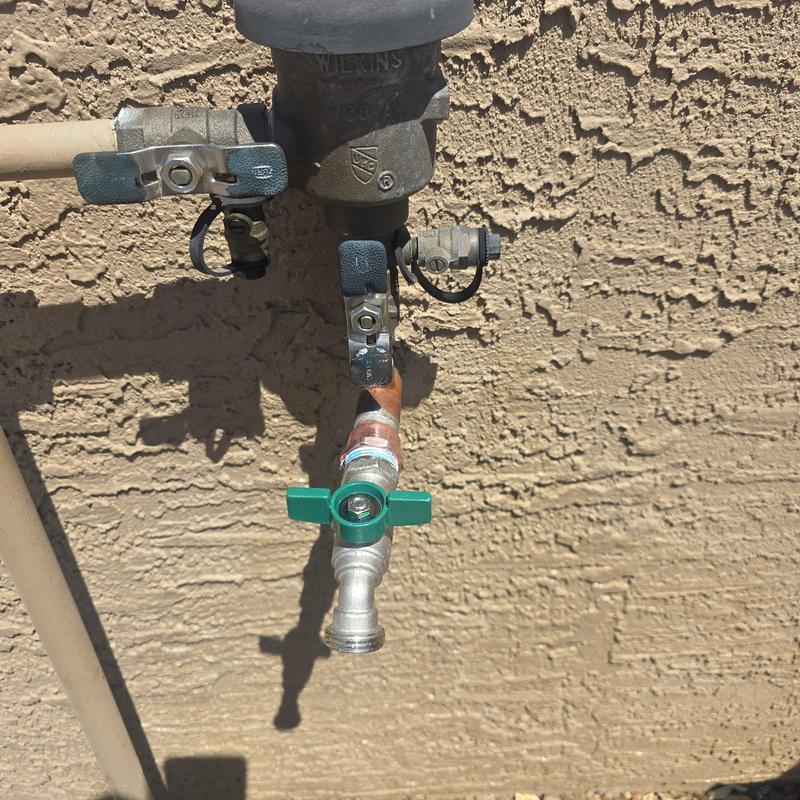 Hose bib replacement with green handle on stucco wall Hose bib replacement with green handle on stucco wall