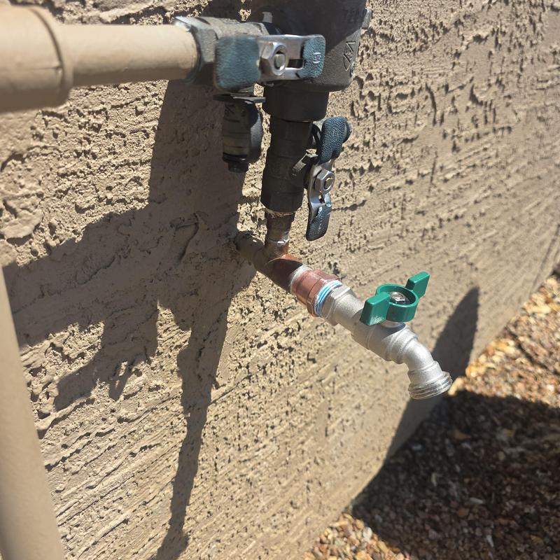 Hose bib replacement with green handle on stucco wall Hose bib replacement with green handle on stucco wall