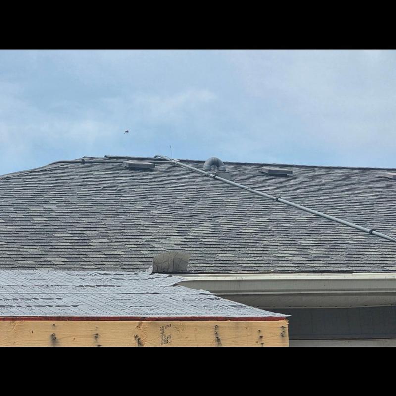 Roof shingles and vent pipe on commercial roof system