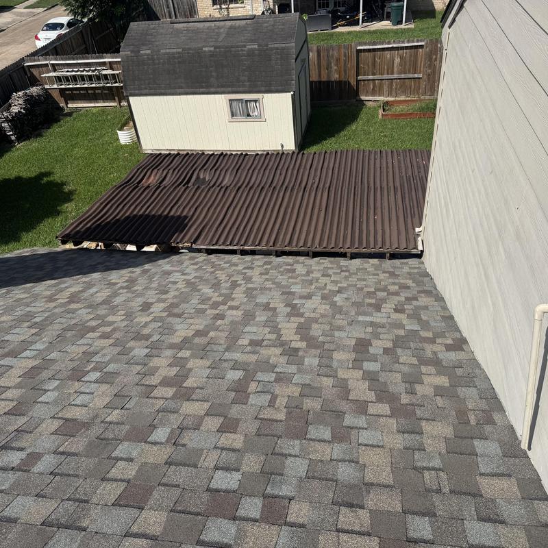 Architectural shingle roof with rusted metal canopy nearby