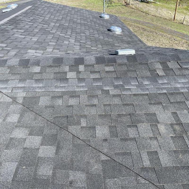 Asphalt shingle roof with vents in rural yard