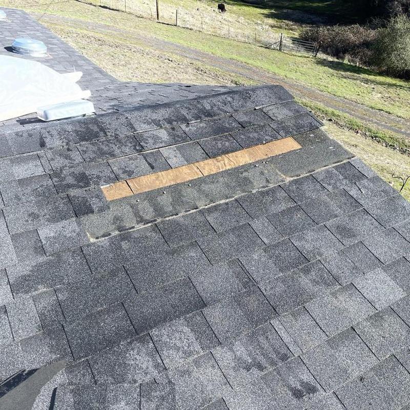 Roof shingles with exposed underlayment and wooden strip