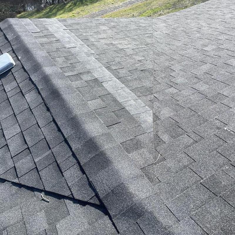 Asphalt shingle ridge cap on residential roof junction