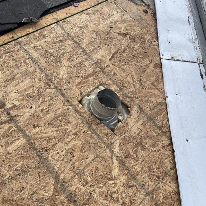 Roof plywood decking with vent pipe opening near metal flashing