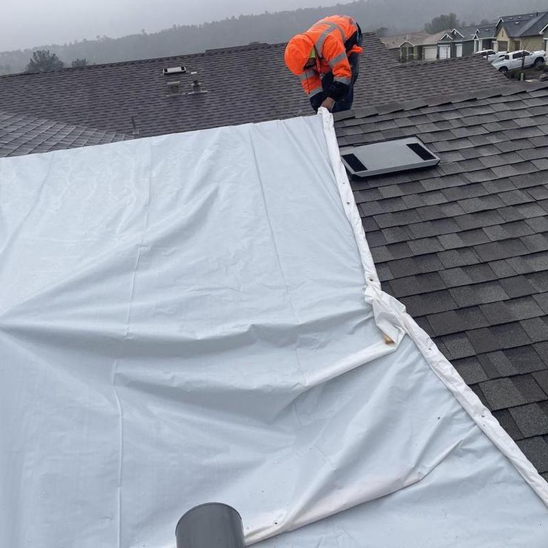 Asphalt shingle roof with temporary tarp installation