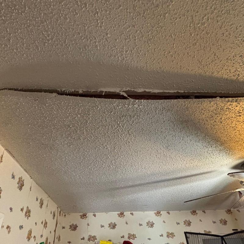 Ceiling separation crack revealing underlying damage