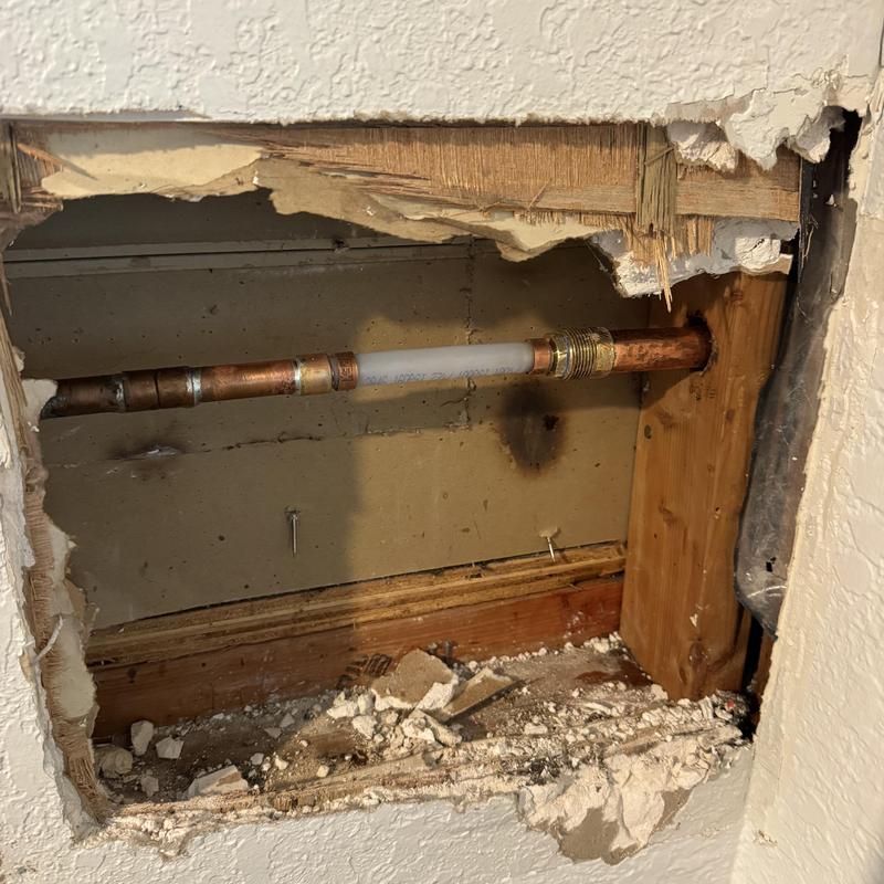 Copper pipe section inside wall with new fittings installed Copper pipe section inside wall with new fittings installed