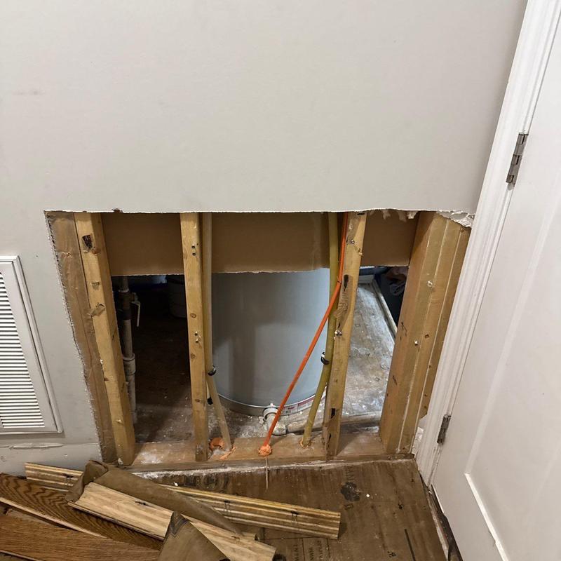 Water heater access with drywall removed and exposed studs