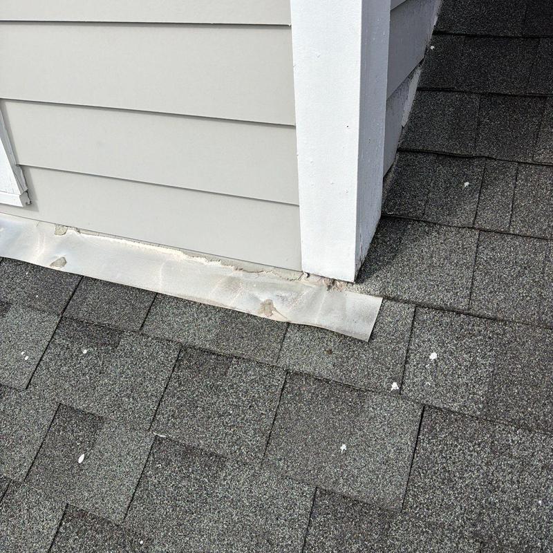 Roof flashing with hail damage on shingle roof