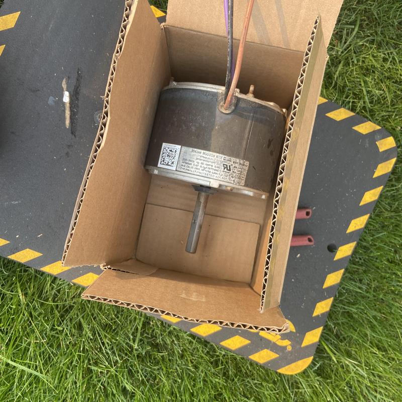 Outdoor condenser motor in cardboard box outdoors Outdoor condenser motor in cardboard box outdoors