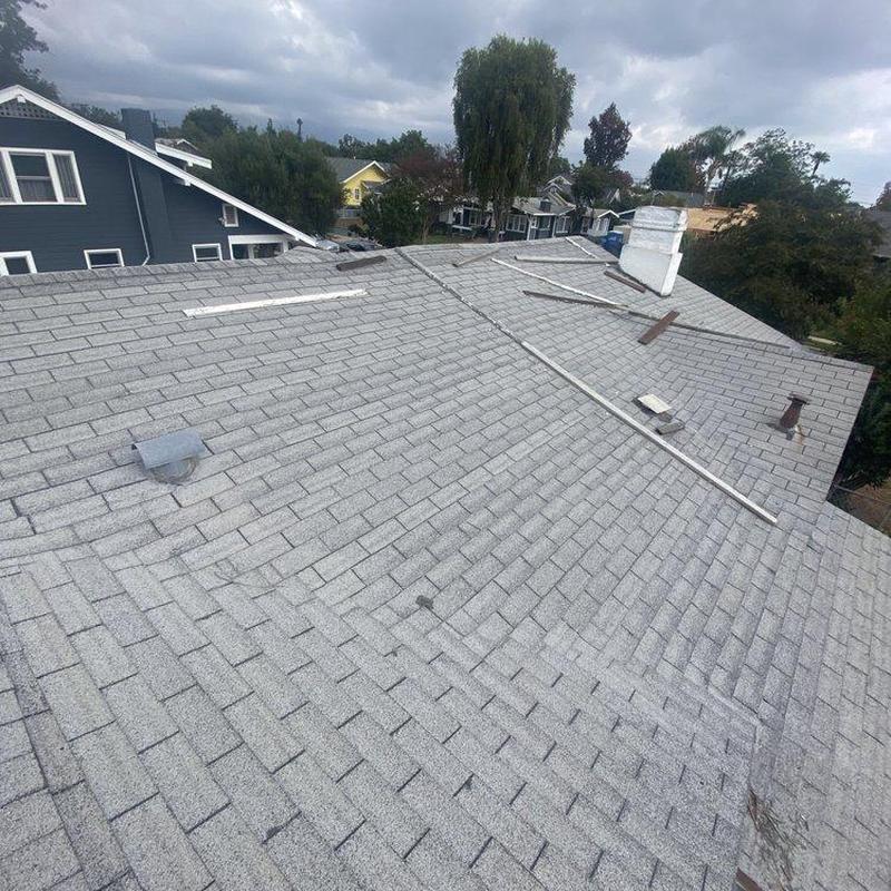 Shingle roof with vents and chimney in cloudy weather Shingle roof with vents and chimney in cloudy weather
